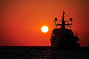 silhouette of a ship in the sea against the sunset