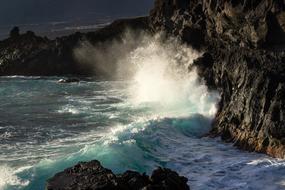 Beautiful, white waves on the rocky shore of the turquoise sea