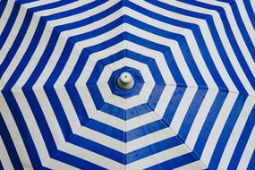 Upper view of the beautiful white and blue striped umbrella