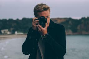 guy with camera on the beach on a cloudy day