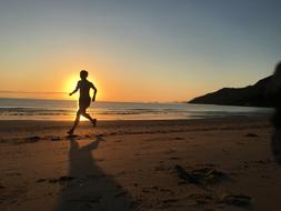 woman runs on Beach at Sunrise