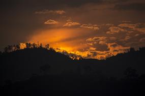 Beautiful landscape of the hills, at colorful sunset in the sky with clouds