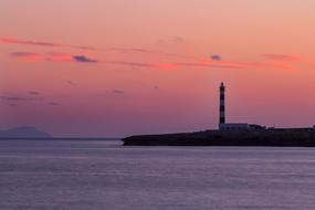distant view of Artrutx lighthouse at dusk