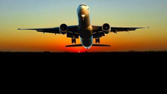 plane taking off against the backdrop of the setting sun