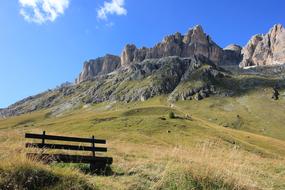 landscape of bench on green hill and mountain