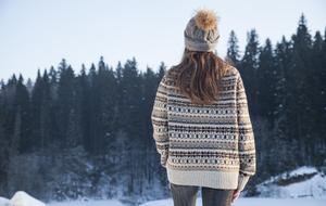 the girl looks into the distance of the forest in winter