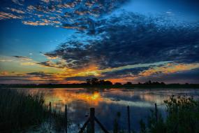 Beautiful landscape of the water, with the reflections, among the plants, at beautiful and colorful sunset