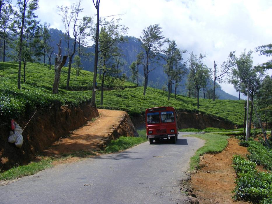 red car drives down the road