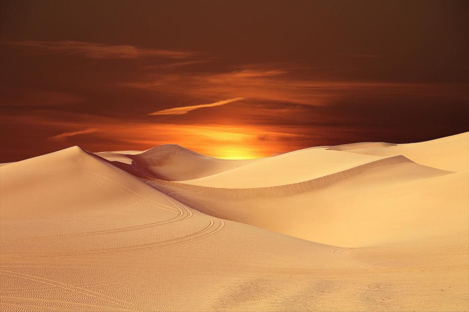 sun over sand dunes at dusk