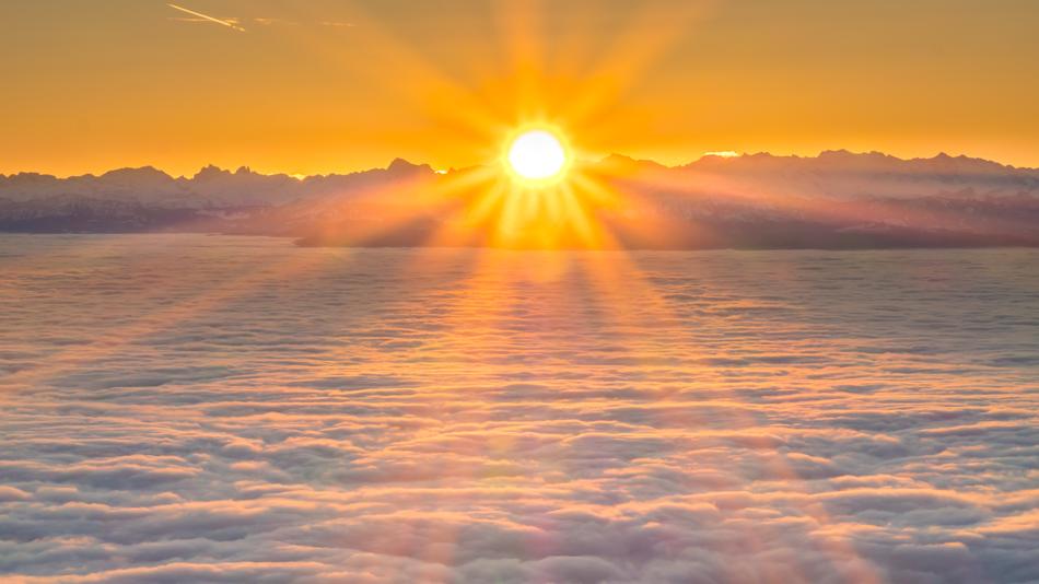 bright sun above the clouds in the alps