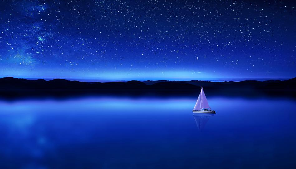 blue twilight over a sailboat on the water