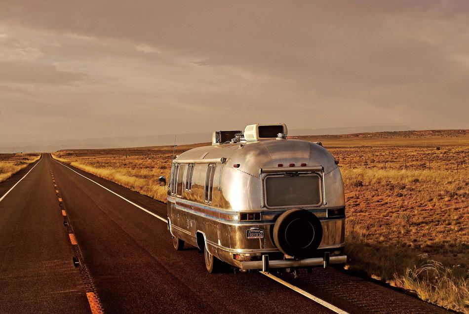 landscape of the vintage camper bus driving on road in wilderness in usa
