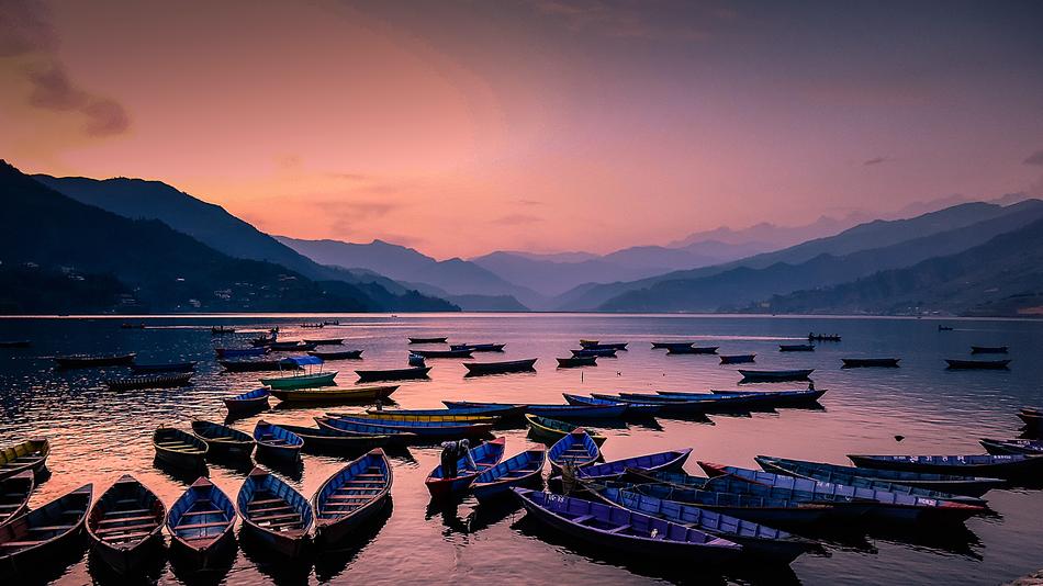 fishing boats on the lake against a pink evening sky