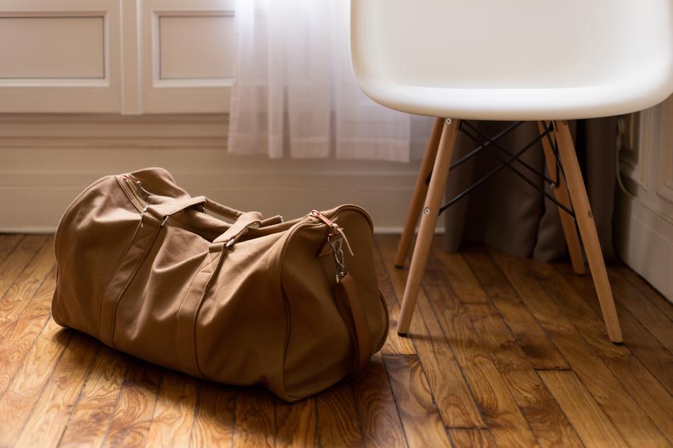 travel bag and white chair in the room