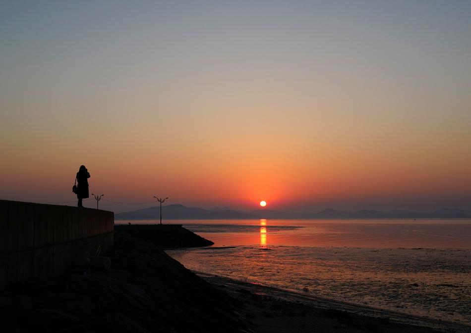 lonely woman on the shores of the warm sea at dawn