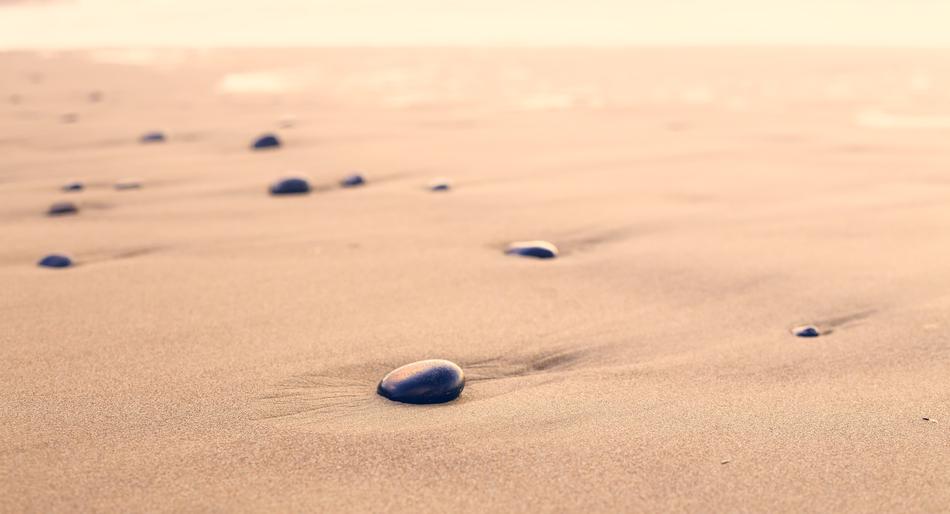 pebbles on pink sand in blurred background