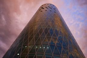 glass skyscraper in cloudy twilight