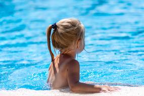 blonde baby in the water on a sunny day