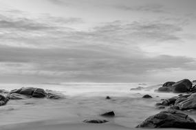 black and white photo of stones on the beach