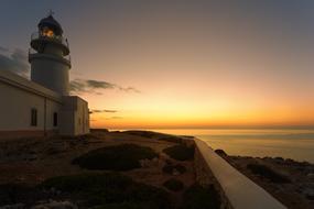 Beautiful landscape of the coast of the lake, with the lighthouse, at beautiful and colorful, gradient sunset