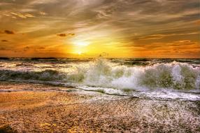 Beautiful landscape of the shiny coast of the North Sea in Denmark, with the waves, at beautiful and colorful sunset