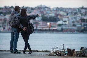 couple stands on the waterfront in Lisbon, Portugal