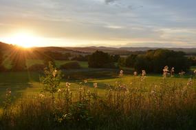 Beautiful and colorful landscape of the fields and hills, with the trees, at beautiful and colorful sunset