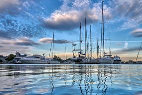 boats in the harbor are reflected in the blue twilight