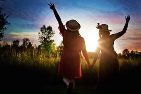 silhouettes of girls in the bright sun at dusk