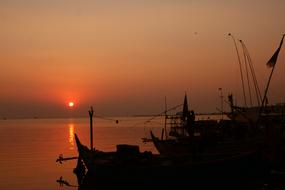 fishing boats near beach at sunset