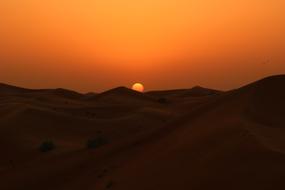 hills of sand in the desert at sunset