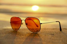 sunglasses on the sand on a blurred background