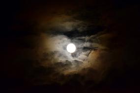 Full moon among cloud haze