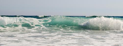 huge turquoise wave on a sunny day