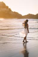 girl walking on Sea beach near Hill