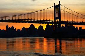 Beautiful landscape with the silhouettes of the bridge and buildings, at beautiful and colorful sunset