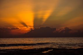 sunset in the clouds on the horizon at dusk over the water