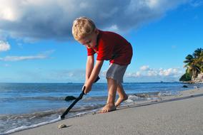 boy with stick on tropical beach