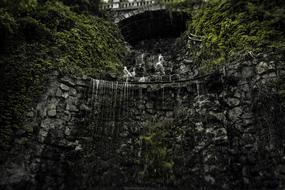 Beautiful, stone arch with the green plants, on the waterfalls