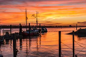 Ship in the beautiful port of Hamburg, Germany, at colorful sunset in the sky