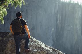 Man hiker with backpack on the stone