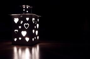 Beautiful, black and white lantern with hearts, with light, at black background