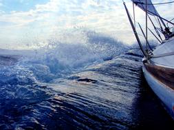 View of the beautiful and colorful water with the waves, from the sailing boat