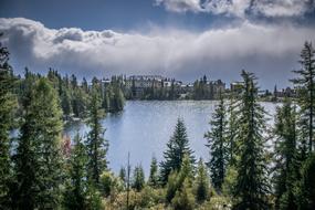 clouds over the lake among green trees