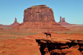 Beautiful landscape with the person on the horse, on the sandstone cliff in the beautiful desert in USA