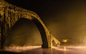 arch bridge over water at night