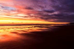 Beautiful beach of the sea, in colorful and beautiful sunset in the clouds, in New Zealand