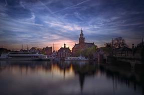 castle architecture is reflected in the water at dusk