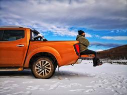 man in an orange pickup truck on a Delmece Plateau