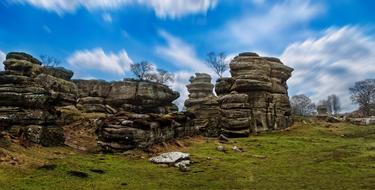 stones on a hill with green grass near trees